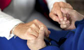 Foto: Betreuerin hält die Hände einer Seniorin